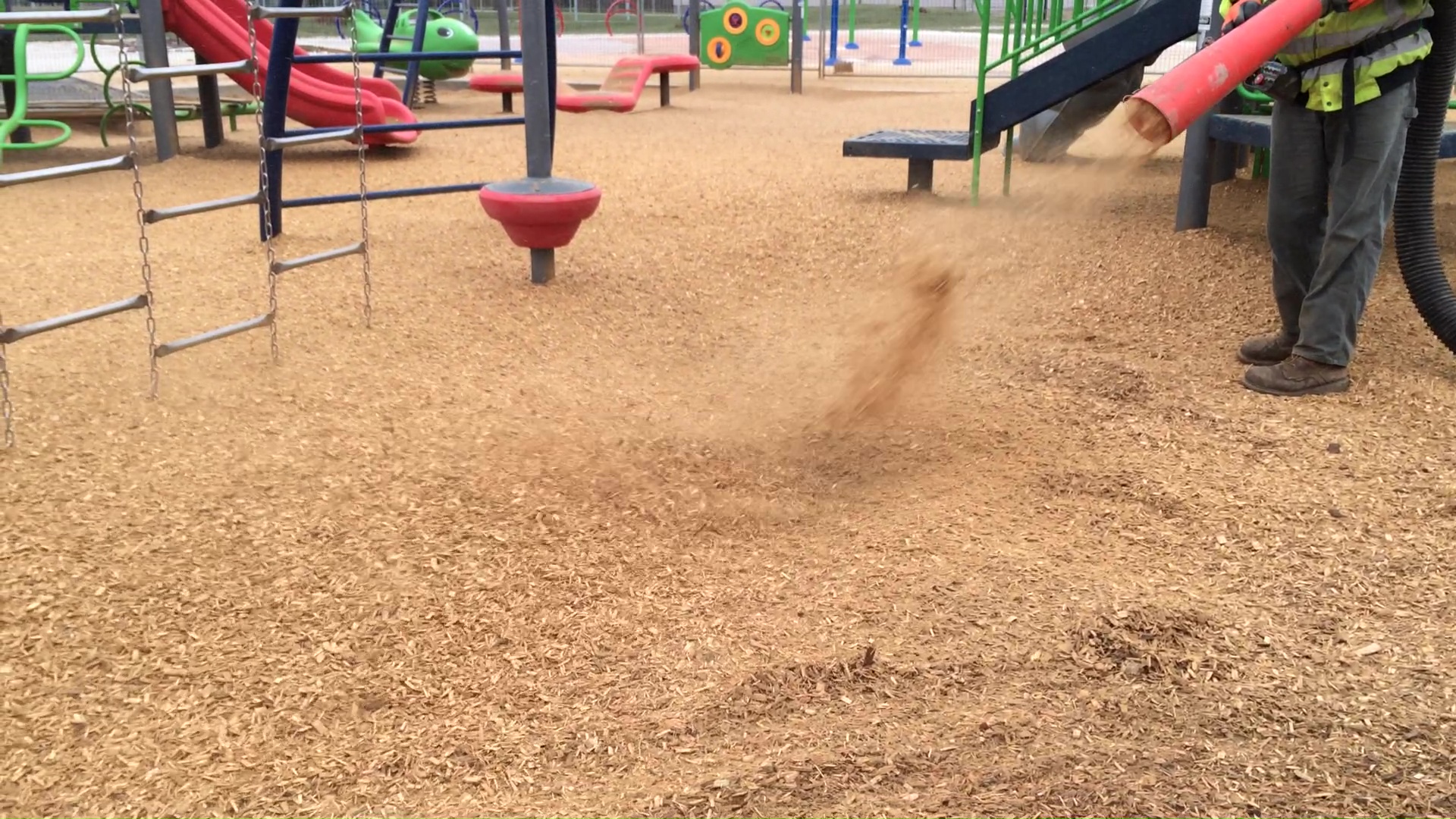A playground slide with a Fibertop wear mat at the bottom